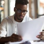 Person reviewing legal documents for their new business, looking focused